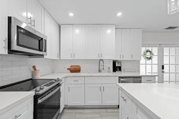 a kitchen with white cabinets stainless steel appliances and sink