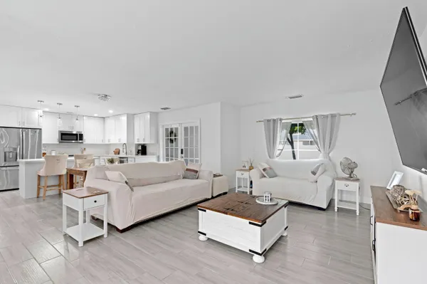 a living room with furniture white walls and wooden floor