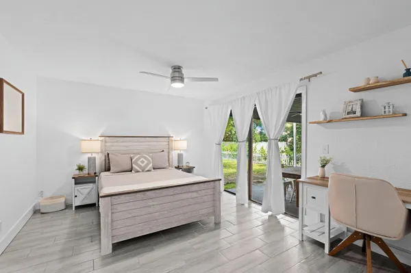 a bedroom with a bed table and a window