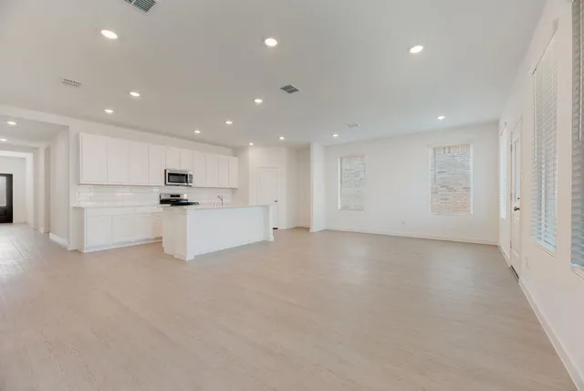 a view of kitchen with white cabinets and refrigerator
