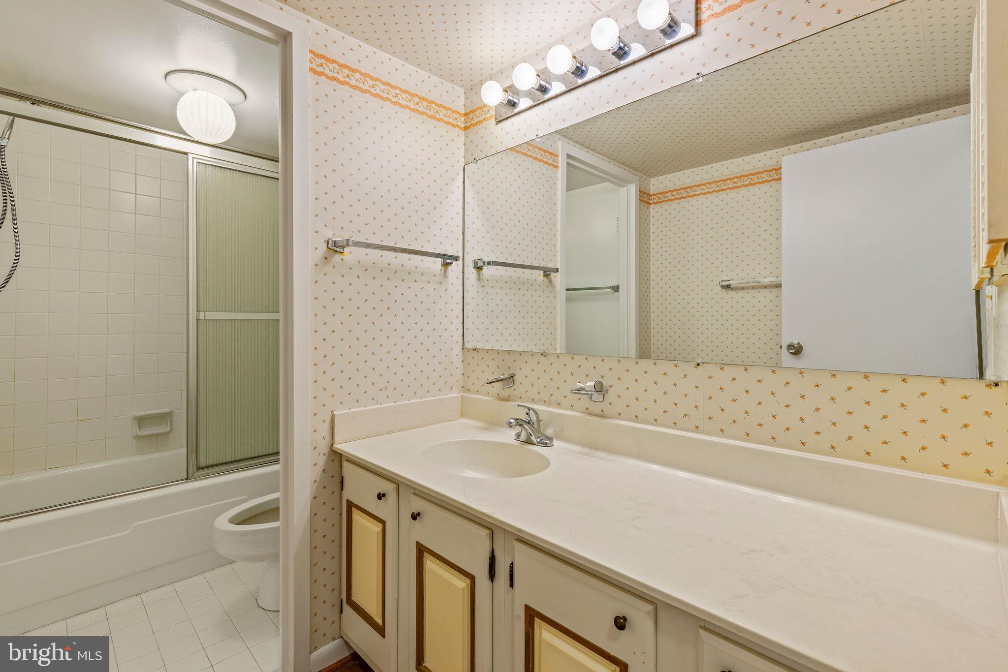 205 East Joppa Road, Unit 1606 Towson, MD 21286 - Photo 21 of 33 a bathroom with a granite countertop sink a toilet and shower