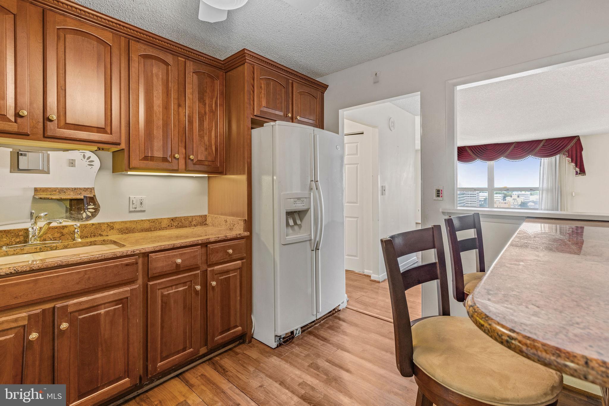 205 East Joppa Road, Unit 1606 Towson, MD 21286 - Photo 25 of 33 a kitchen with stainless steel appliances granite countertop a refrigerator and wooden cabinets