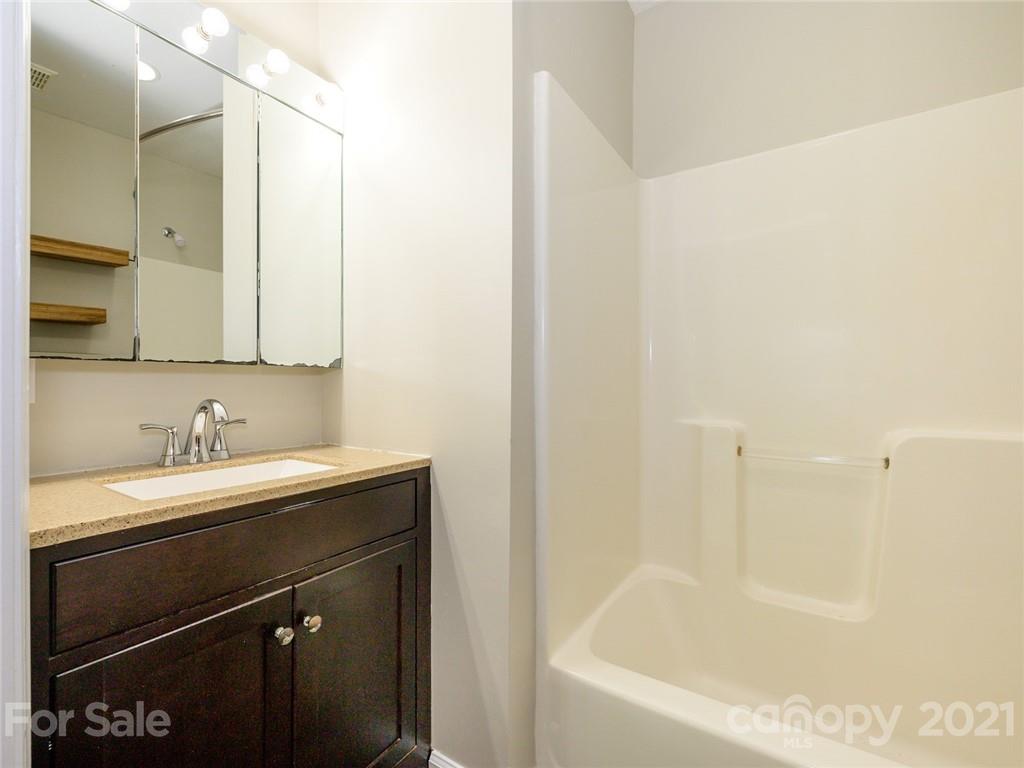 513 West Rebound Road Lancaster, SC 29720 - Photo 21 of 31 a bathroom with a bathtub sink vanity and mirror
