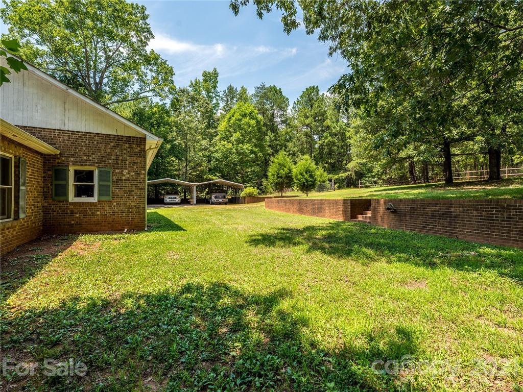 513 West Rebound Road Lancaster, SC 29720 - Photo 27 of 31 a backyard of a house with plants and large tree