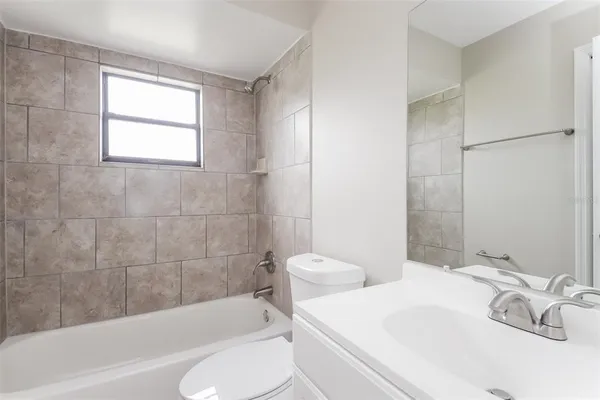 a bathroom with a white bath tub a toilet and a sink
