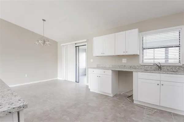a kitchen with granite countertop white cabinets and white appliances