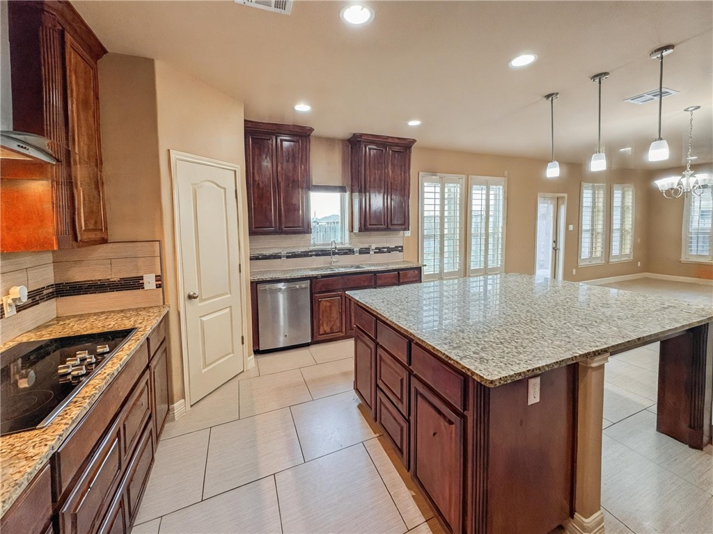 1832 Bay Landing Drive Portland, TX 78374 - Photo 11 of 29 a kitchen with kitchen island granite countertop a stove a sink a oven and a refrigerator