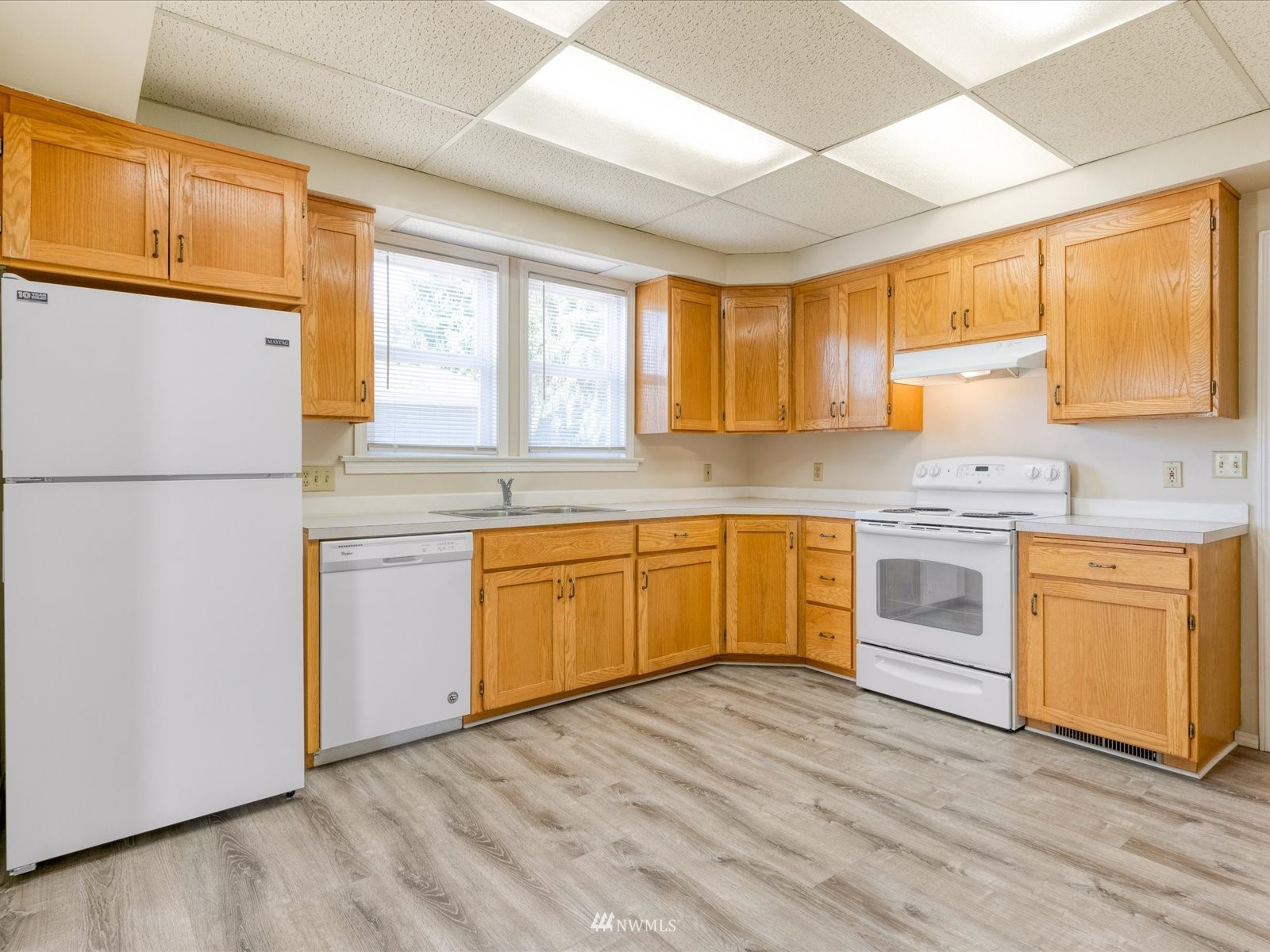 97 Logan Avenue South Renton, WA 98057 - Photo 4 of 32 a kitchen with granite countertop white cabinets and white appliances