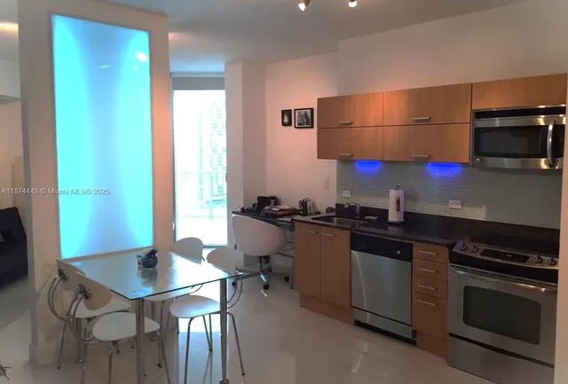 a kitchen with stainless steel appliances a stove a sink and a refrigerator