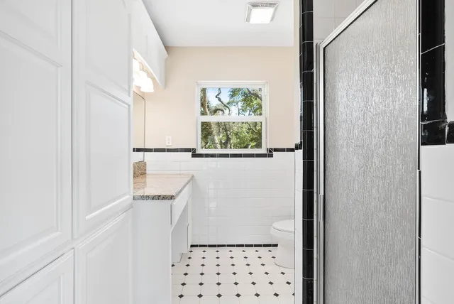 a bathroom with a window a sink and a shower