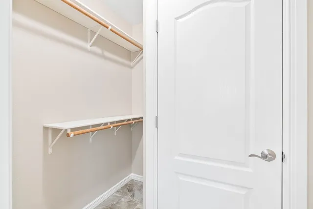 a view of walk in closet with clothes