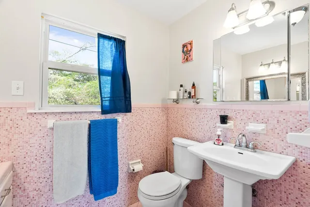 a bathroom with a sink a toilet and mirror