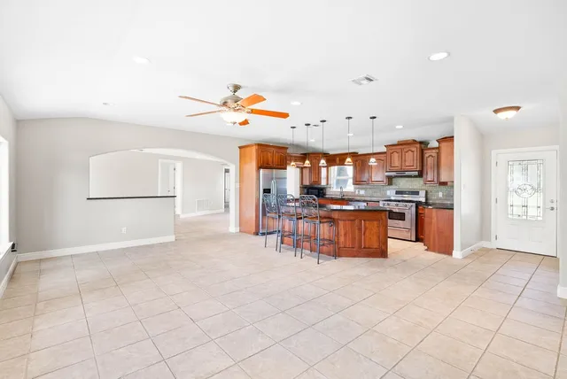 a kitchen with stainless steel appliances kitchen island granite countertop a sink and a stove