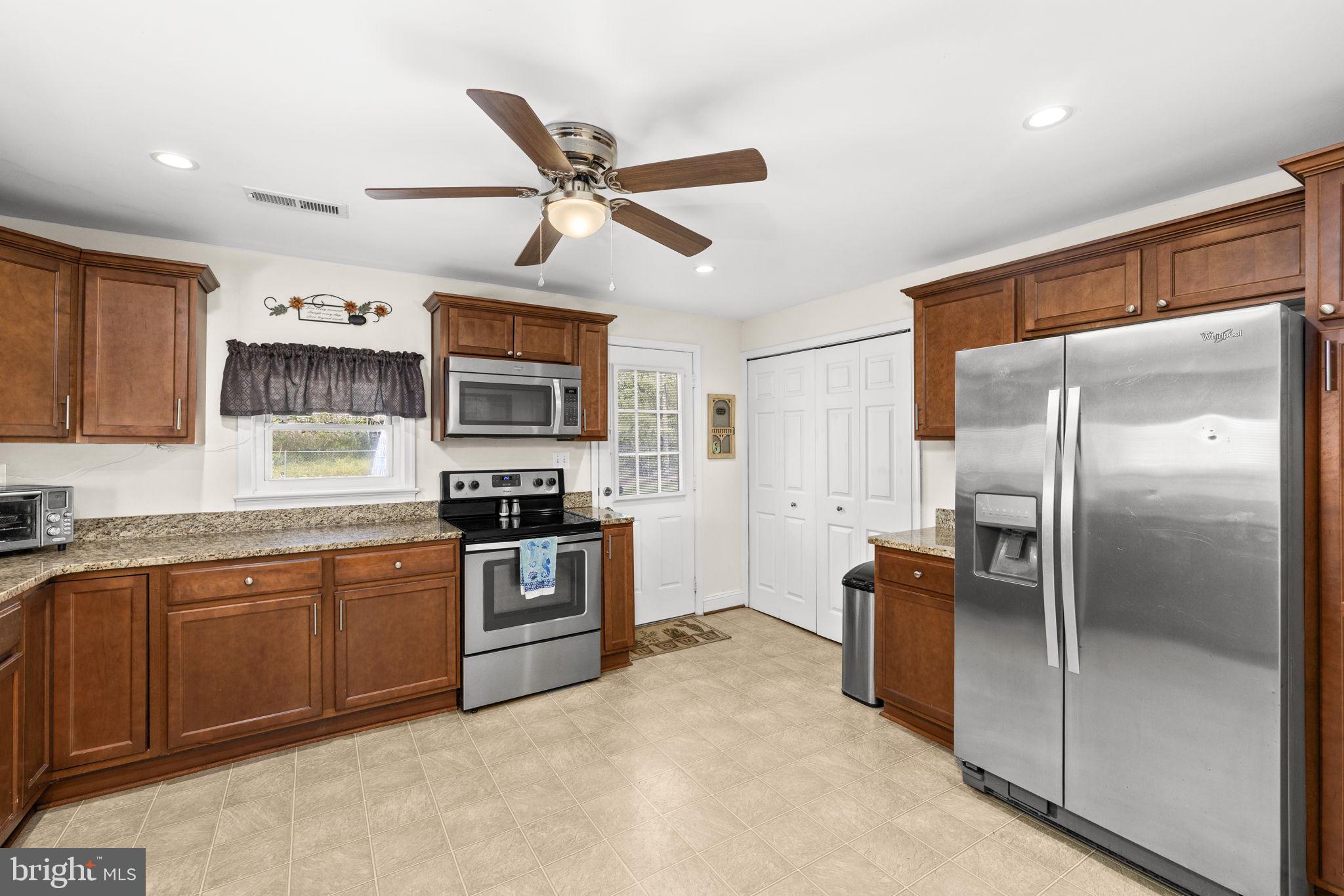 66 Kelley Road Fredericksburg, VA 22405 - Photo 12 of 35 a kitchen with stainless steel appliances granite countertop a refrigerator a stove a sink and a microwave