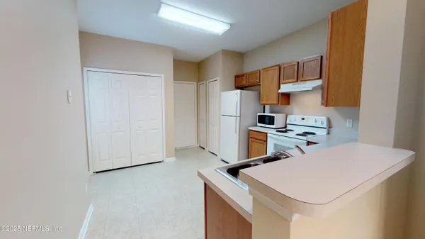 a kitchen with cabinets and a refrigerator