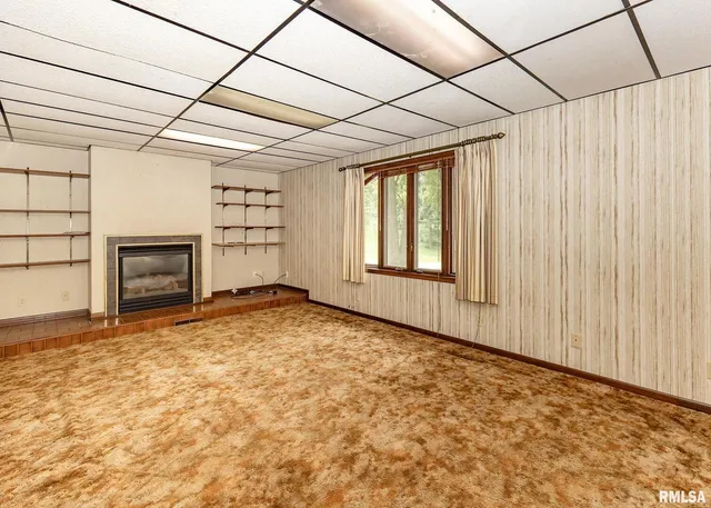 a view of empty room with fireplace and windows