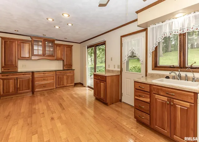 a large kitchen with stainless steel appliances granite countertop a large window and a sink