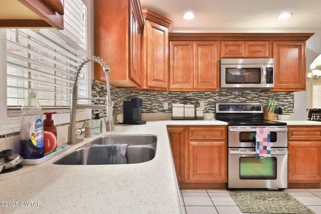 a kitchen with stainless steel appliances granite countertop a sink and a microwave