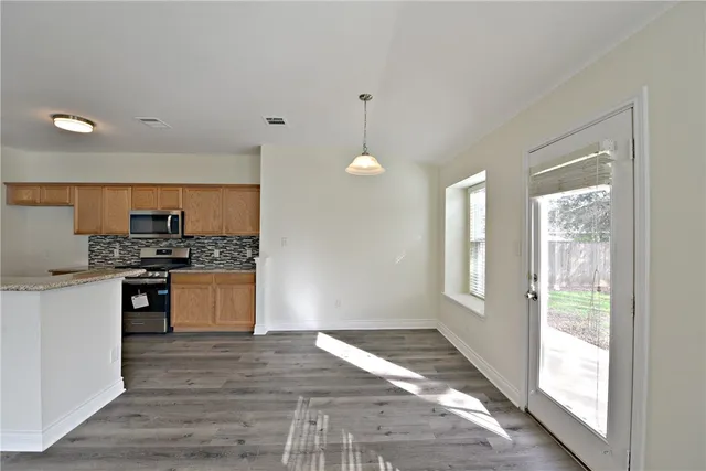a kitchen with granite countertop a stove a sink and a refrigerator