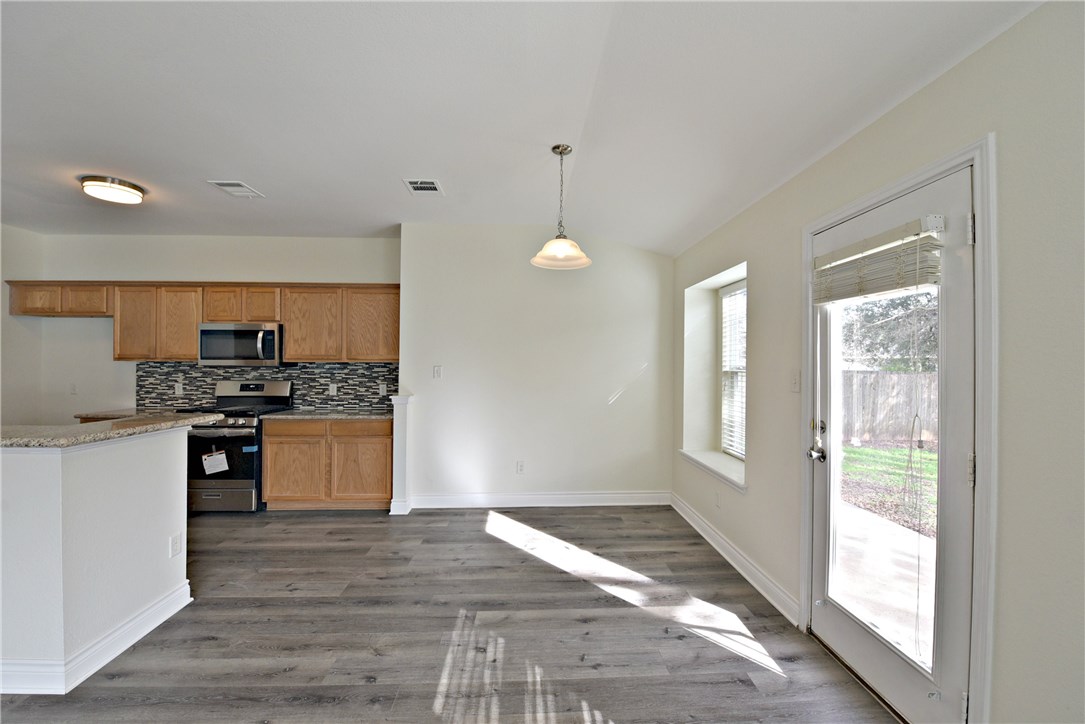 3665 Spring Canyon Trail Round Rock, TX 78681 - Photo 8 of 21 a kitchen with granite countertop a stove a sink and a refrigerator