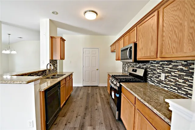 a kitchen with stainless steel appliances granite countertop a stove and a sink