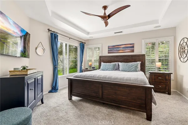 a bedroom with a bed and a flat tv screen on dresser