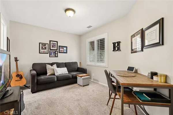 a living room with furniture a flat screen tv and a window