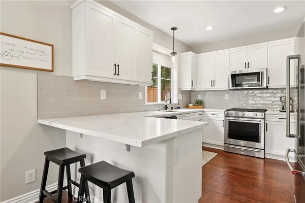 a kitchen with kitchen island a stove and a sink with wooden floor