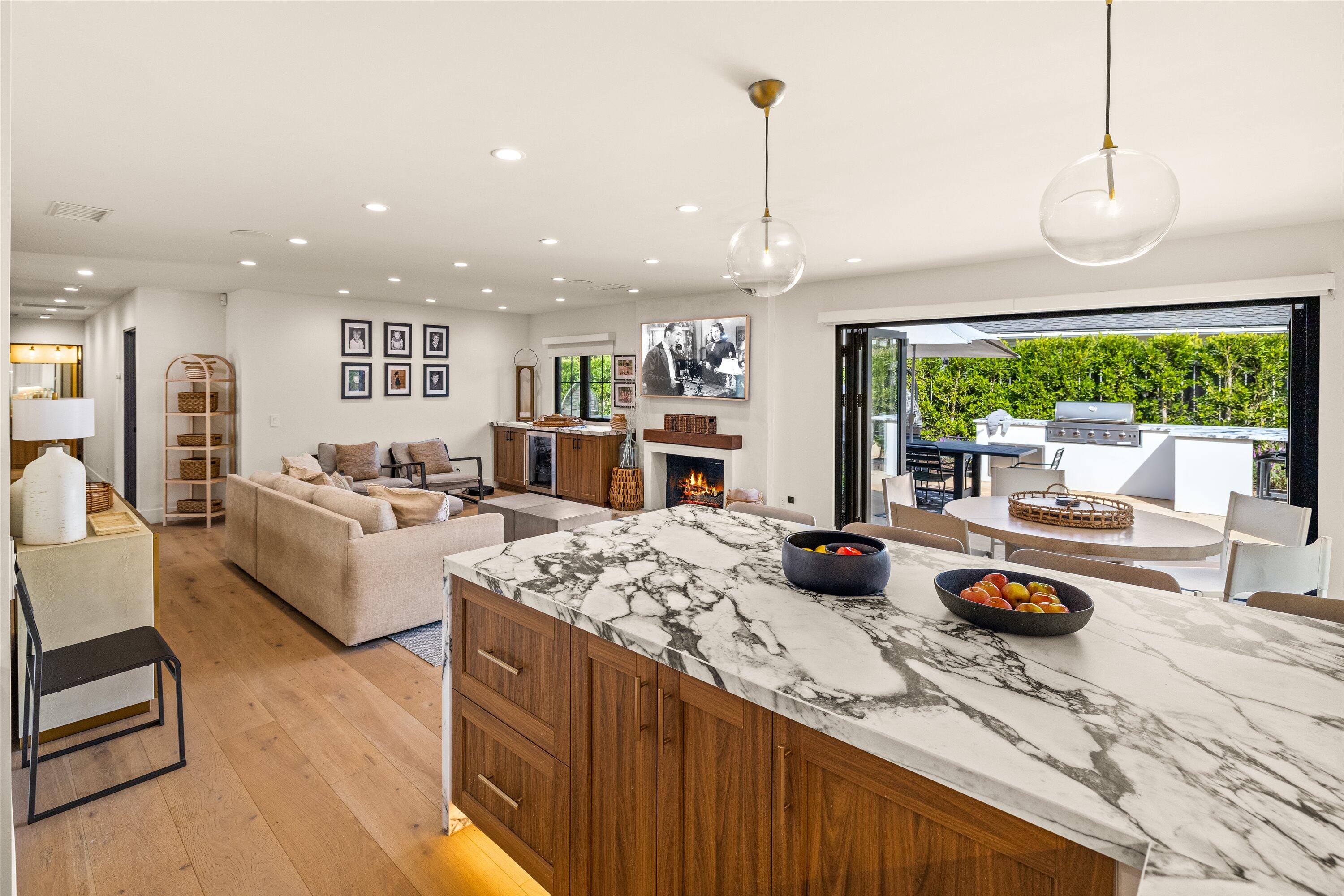 a kitchen with stainless steel appliances granite countertop a stove a sink dishwasher and white cabinets with wooden floor