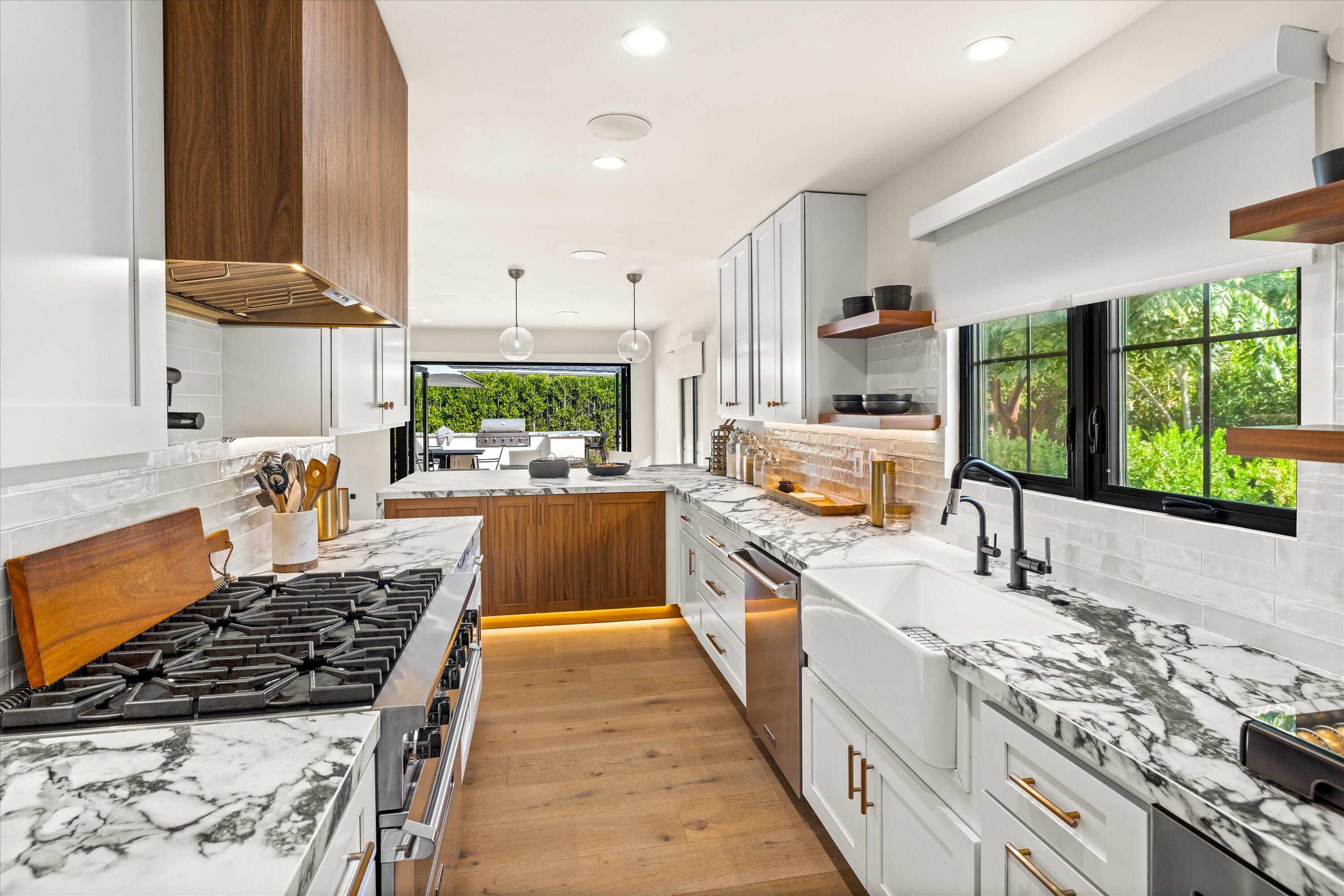 516 Mills Way Goleta, CA 93117 - Photo 13 of 38 a large kitchen with stainless steel appliances granite countertop a stove top oven a sink dishwasher and cabinets with wooden floor