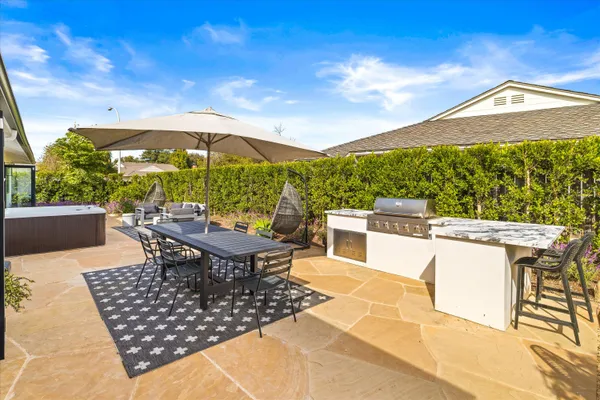 a view of a roof deck with table and chairs under an umbrella