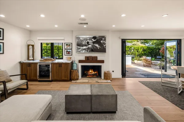 a living room with furniture a fireplace and a floor to ceiling window