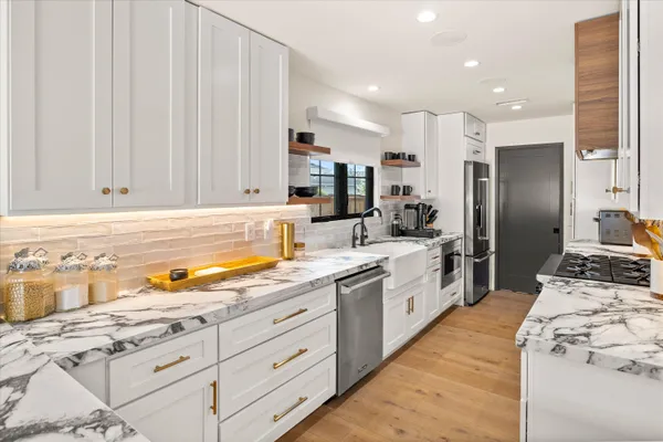 a large kitchen with stainless steel appliances kitchen island granite countertop a sink and cabinets