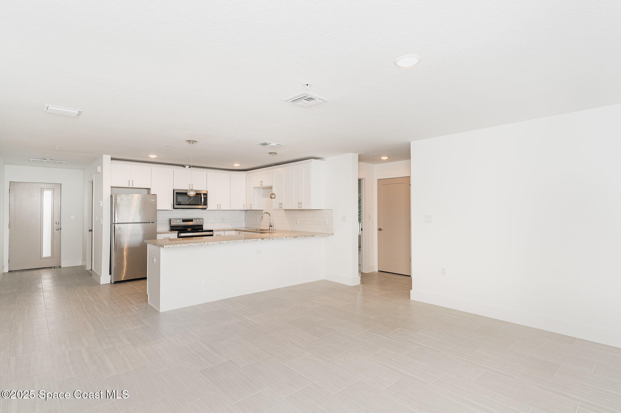 1625 Par Street, Unit 1107 Palm Bay, FL 32905 - Photo 4 of 32 a view of a kitchen with refrigerator and microwave