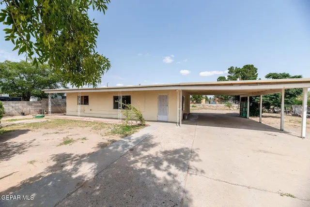 a view of a house with a patio and a yard