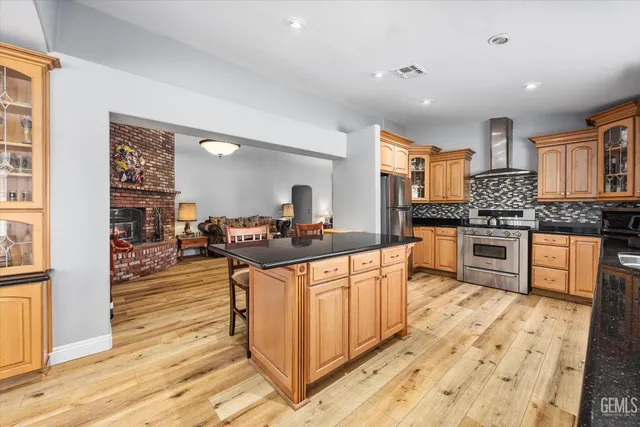 a large kitchen with stainless steel appliances kitchen island granite countertop a stove and a sink