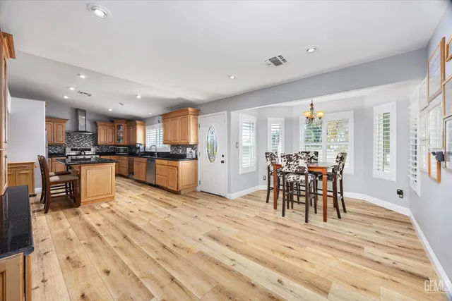 a view of kitchen with dining table wooden floor dining table and stainless steel appliances