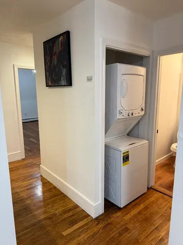 a kitchen with a refrigerator and wooden floor
