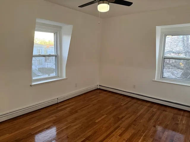 a view of a room with wooden floor and fan