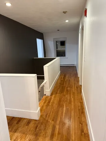 a view of a room with wooden floor and a window