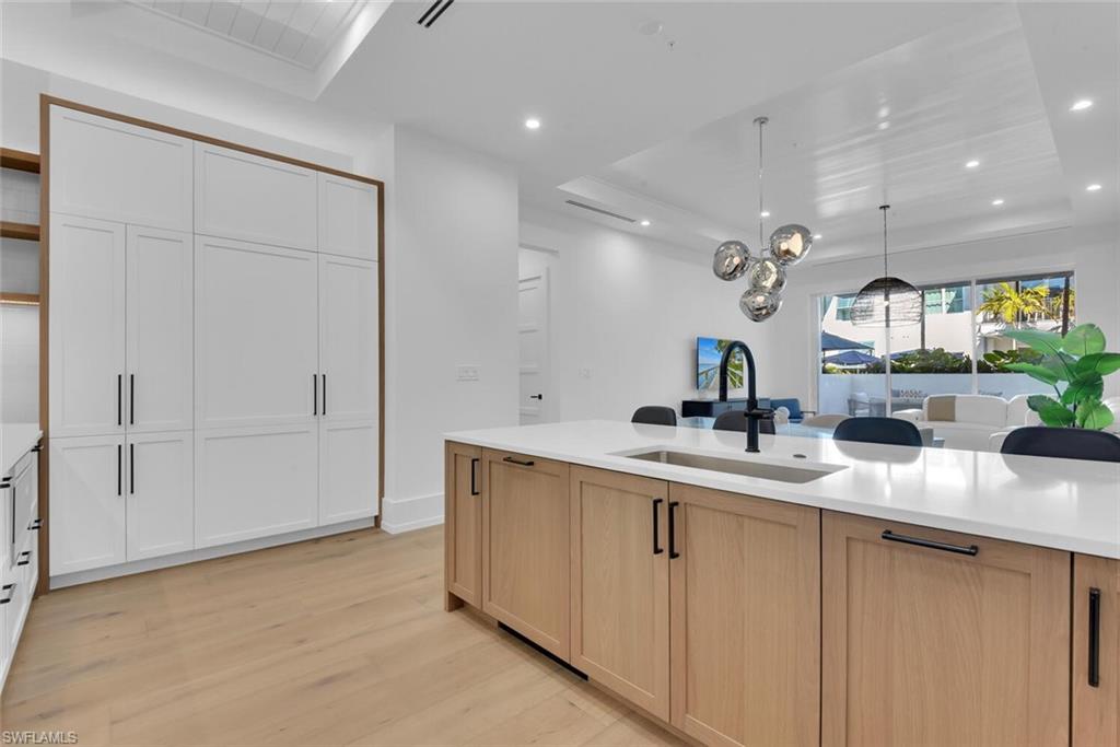 201 8th Street South, Unit 209 Naples, FL 34102 - Photo 11 of 41 a kitchen with kitchen island white cabinets and sink