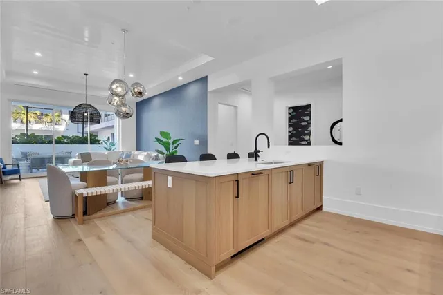 a large white kitchen with a large island in the center