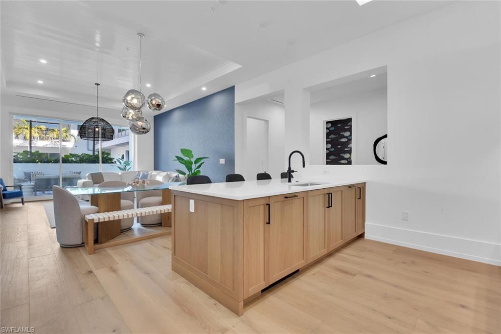 201 8th Street South, Unit 209 Naples, FL 34102 - Photo 12 of 41 a large white kitchen with a large island in the center