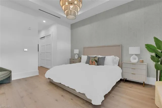 a spacious bedroom with a bed and a chandelier