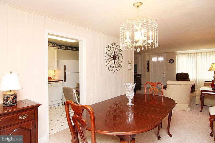 1227 Newfield Road Baltimore, MD 21207 - Photo 4 of 16 a dining room with furniture a chandelier and wooden floor