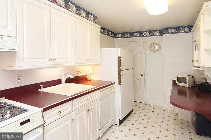 1227 Newfield Road Baltimore, MD 21207 - Photo 7 of 16 a kitchen with a sink and a refrigerator