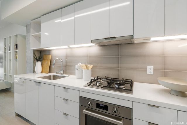 a kitchen with stainless steel appliances granite countertop a sink a stove and cabinets
