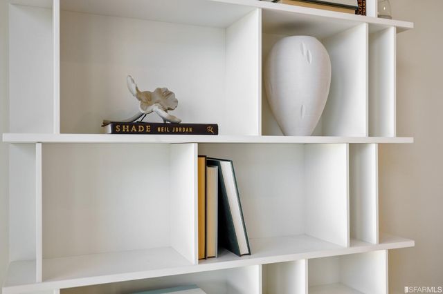 a bedroom with bed and a painting on the wall