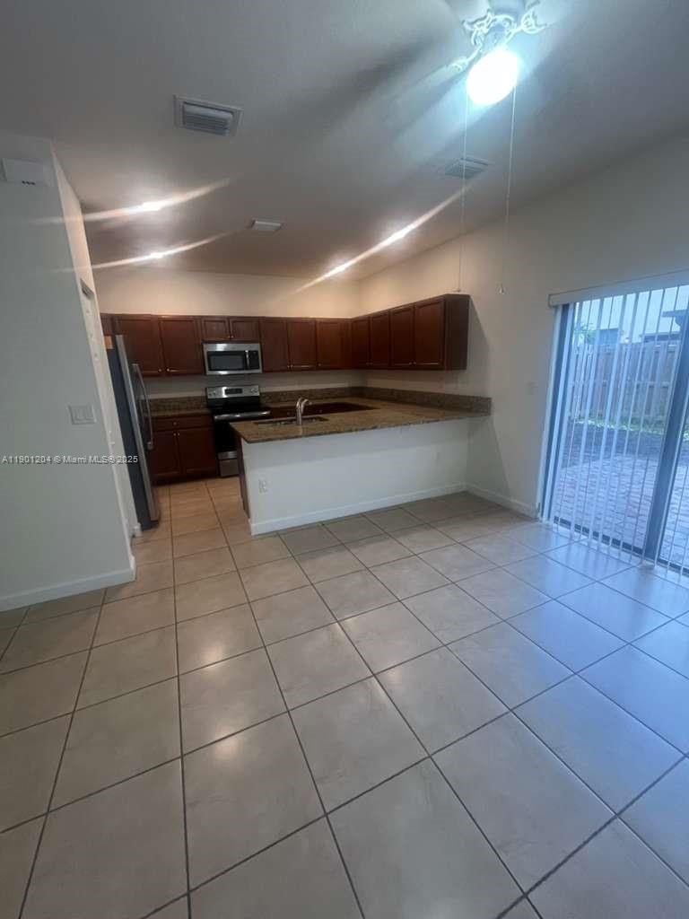 11481 Southwest 250th Street, Unit 11481 Homestead, FL 33032 - Photo 4 of 12 a view of an empty room with wooden floor