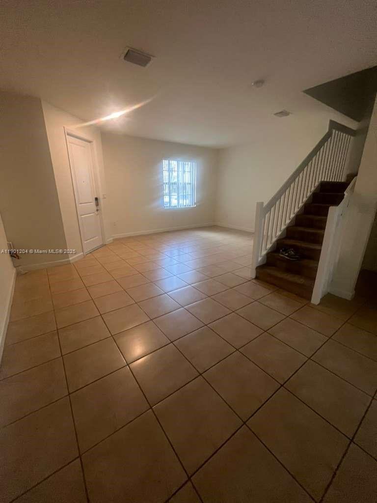 11481 Southwest 250th Street, Unit 11481 Homestead, FL 33032 - Photo 6 of 12 a view of an empty room with a window
